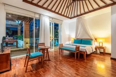 a bedroom with a bed and a table and chairs at AQ-VA Hotel & Villas Seminyak in Legian