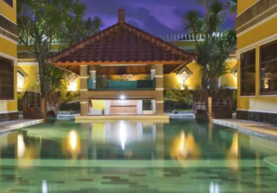 a swimming pool in front of a house at Apel Villa Sanur in Sanur
