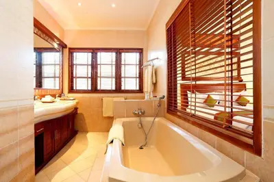 a bathroom with a large tub and a sink at Apel Villa Sanur in Sanur