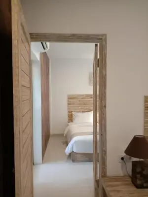 a bedroom with a bed and a door leading into a room at Tirtha Khayangan in Canggu