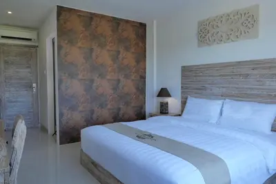 a bedroom with a large white bed with a wooden headboard at Tirtha Khayangan in Canggu