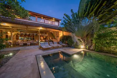a backyard with a swimming pool and a house at Villa Teman - Luxury 4BR Villa in Central Seminyak - HUGE POOL in Seminyak
