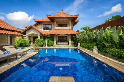 a villa with a swimming pool in front of a house at Villa Deh Simba at Oberoi in Seminyak