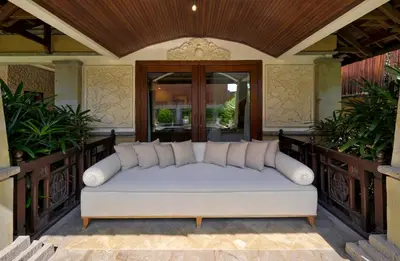 a white couch on a porch with plants at Villa Deh Simba at Oberoi in Seminyak