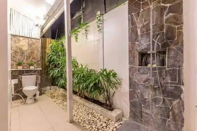 a bathroom with a toilet and plants on the wall at Villa Alegria in Seminyak