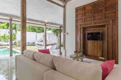 a living room with a large couch and a tv at Villa Alegria in Seminyak