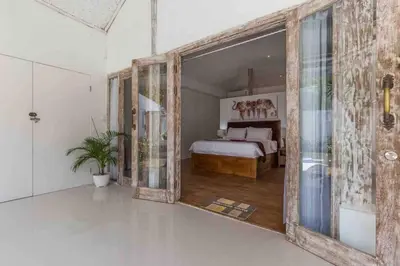 a bedroom with a bed and a large sliding glass door at Villa Alegria in Seminyak