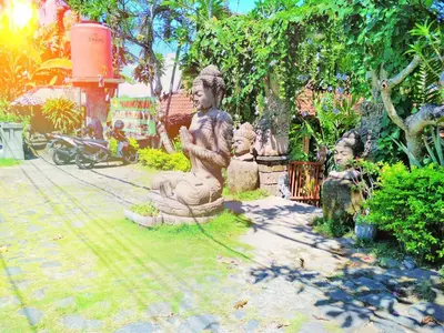 a group of statues sitting in a garden at Bali Eco Living Yoga Healing Meditation and Retreat Center in Denpasar
