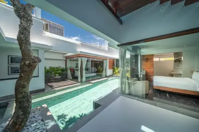 a bedroom and pool in a villa at Villa Tykhe - Modern Balinese 4BR Pool Villa in Central Seminyak in Seminyak