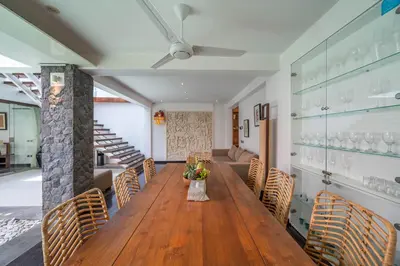 a dining room with a wooden table and chairs at Villa Tykhe - Modern Balinese 4BR Pool Villa in Central Seminyak in Seminyak