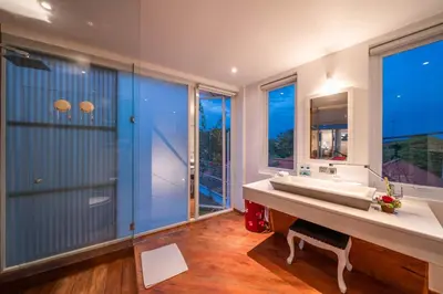 a bathroom with a large tub and a large window at Villa Tykhe - Modern Balinese 4BR Pool Villa in Central Seminyak in Seminyak
