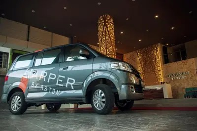 a silver suv parked in front of a building at Harper Kuta Hotel by ASTON in Legian