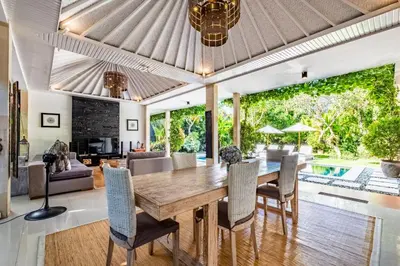 an open living room with a wooden table and chairs at Central Seminyak Villa Martini in Seminyak
