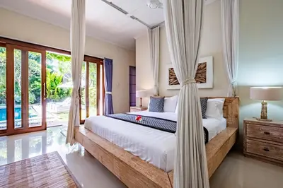 a bedroom with a bed with a canopy at Central Seminyak Villa Martini in Seminyak