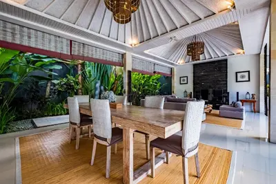 a dining room with a wooden table and chairs at Central Seminyak Villa Martini in Seminyak