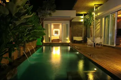 a swimming pool in the middle of a house at night at hu'u Villas in Seminyak