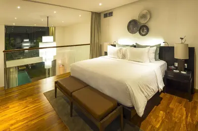 a bedroom with a large white bed and a window at hu'u Villas in Seminyak