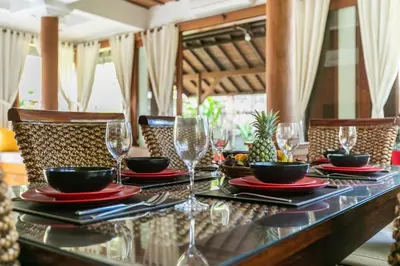a table with glasses and plates of food on it at Listien Villa N3 in Seminyak