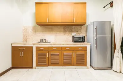a kitchen with wooden cabinets and a stainless steel refrigerator at Listien Villa N3 in Seminyak