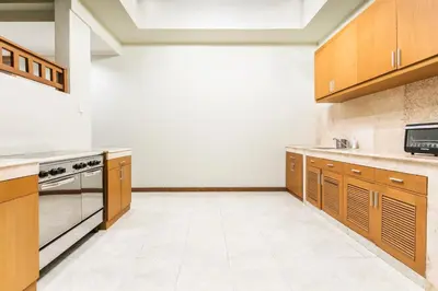a large kitchen with wooden cabinets and appliances at Listien Villa N3 in Seminyak