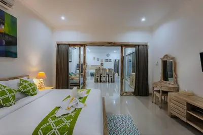 a bedroom with a large bed and a living room at Villa Cathy, Seminyak - Private 3 Bedroom Pool Villa! in Seminyak