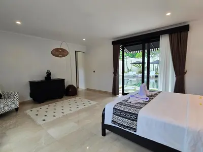 a bedroom with a bed and a large window at Villa Akasha Luxury 6 bedroom villa near beach in Canggu