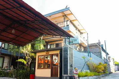 a building with a teddy bear sitting in front of it at Putu Guest House 2 in Canggu