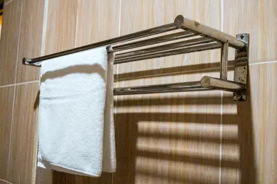 a towel rack in a bathroom with a white towel at Putu Guest House 2 in Canggu