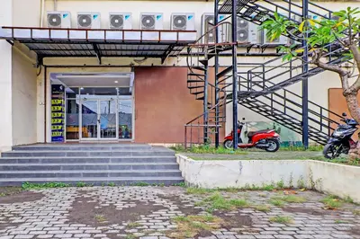 a scooter parked in front of a building with stairs at Guest House Simalem in Legian