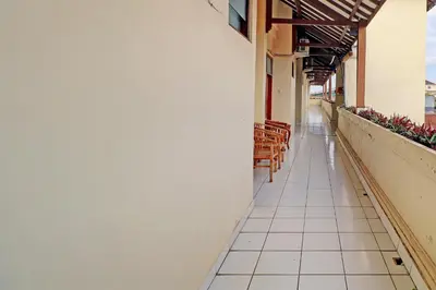 an empty corridor of a building with benches at Guest House Simalem in Legian