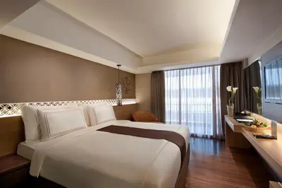 a hotel room with a large bed and a window at Ramada by Wyndham Bali Sunset Road Kuta in Kuta