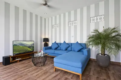a living room with a blue couch and a tv at La Fortuna in Seminyak