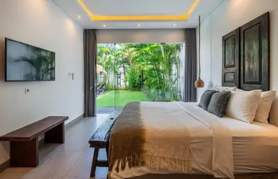 a bedroom with a large bed and a large window at Villa WoW Canggu in Canggu
