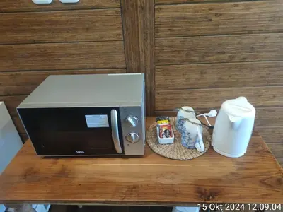 a microwave sitting on top of a wooden table at Atra Bambulogy Villa by Bambulogy Resort in Kerobokan