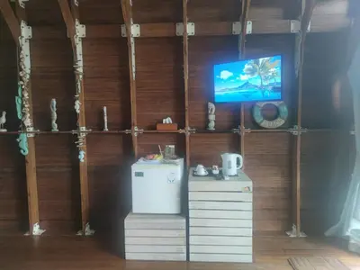 a room with a refrigerator and a tv on a wall at Atra Bambulogy Villa by Bambulogy Resort in Kerobokan