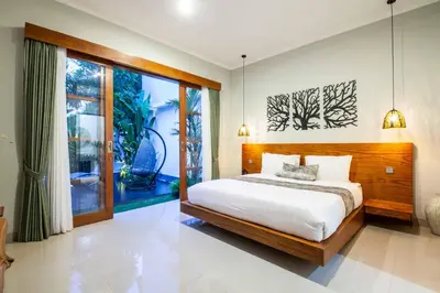 a bedroom with a bed and a large window at Villa Voyage 4 in Seminyak