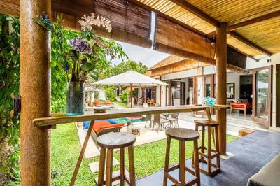 an outdoor bar in a villa with stools at Madu Villa Seminyak in Seminyak