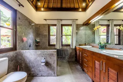 a bathroom with a tub and a toilet and a sink at Madu Villa Seminyak in Seminyak