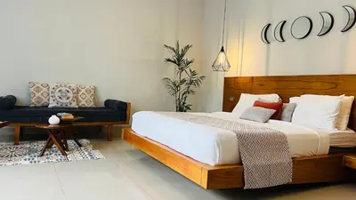 a bedroom with a large bed and a couch at Villa Voyage 5 in Seminyak