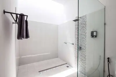 a bathroom with a shower with a glass door at Villa Voyage 5 in Seminyak