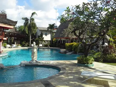 a statue in the middle of a pool with a fountain at Ananda Resort Seminyak in Seminyak