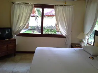 a bedroom with a large white bed and a window at Ananda Resort Seminyak in Seminyak