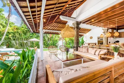 an outdoor living room with a pool and tables and chairs at Villa Berlin - Private 6 BDR Villa in Seminyak with Pool and Garden in Seminyak