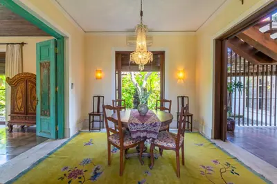 a dining room with a table and chairs and a chandelier at Villa Angsa by Nakula in Sanur