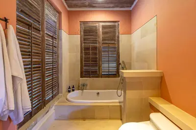 a bathroom with a tub and a toilet and a sink at Villa Angsa by Nakula in Sanur