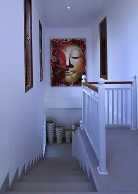 a staircase in a house with a painting on the wall at Bali Villas Arta in Seminyak