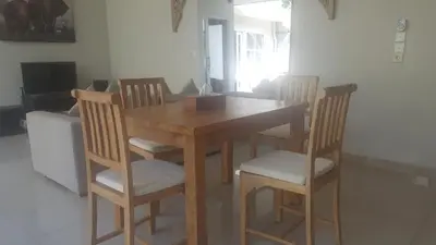 a dining room table with four chairs and a table at Bali Villas Arta in Seminyak