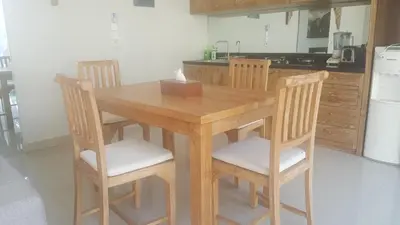 a wooden table and chairs in a kitchen at Bali Villas Arta in Seminyak
