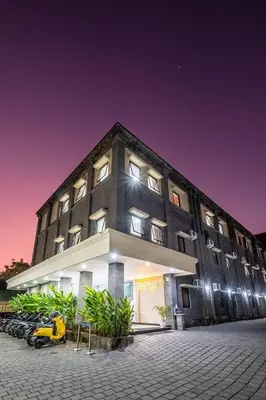 a building with a motorcycle parked in front of it at Ganandra Stay Denpasar in Denpasar