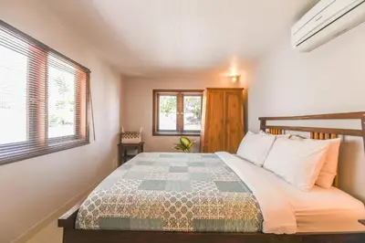 a bedroom with a bed and two windows at Amalia Swan Haven Villa Seminyak in Seminyak